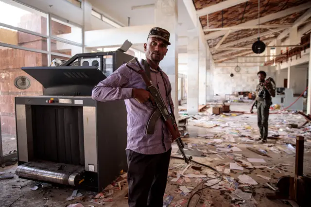 Amhara Fano militia fighters walk in the ransacked terminal at the Lalibela airport in Lalibela, on December 7, 2021.