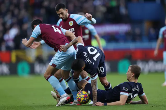 Four players in a slide tackle