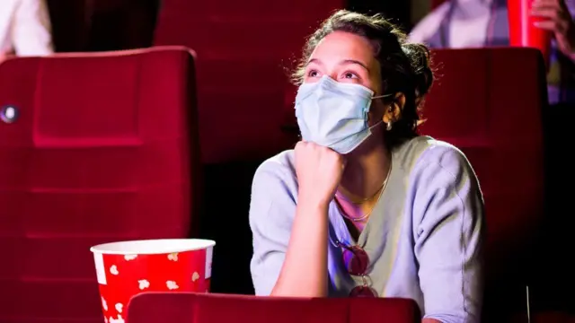 Woman wearing a mask in a cinema