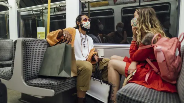 A couple wearing face coverings on the Metro