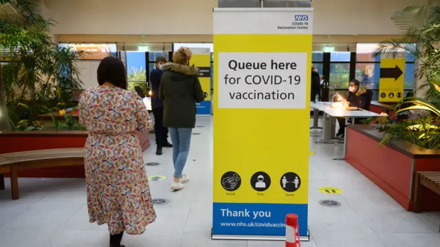 People queue to receive booster shots at a vaccination centre in Ramsgate, Kent