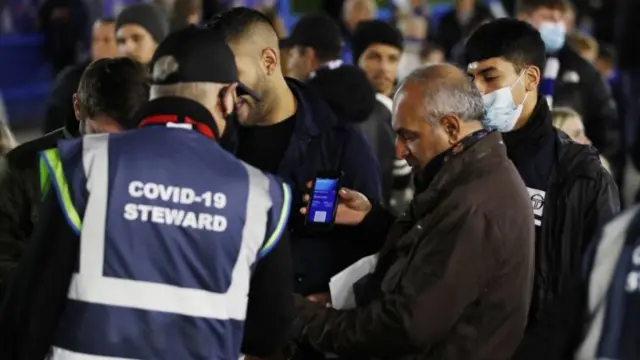 Football fans have their Covid passes checked at the Chelsea v Everton match