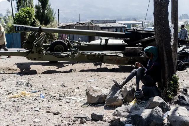 A man looks at a destroyed heavy artillery equipment in Hayk, Ethiopia