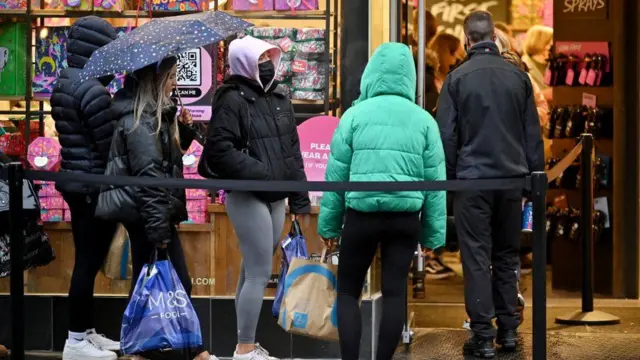 People queuing outside shop