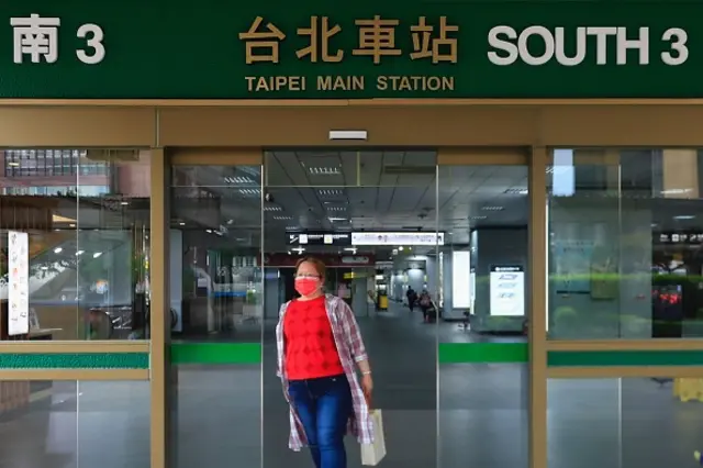 A person wearing a mask leaving Taipei station