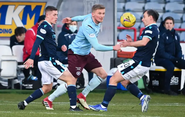 Hearts Taylor Moore is pressured by Dundee's Luke McCowan and Paul McGowan