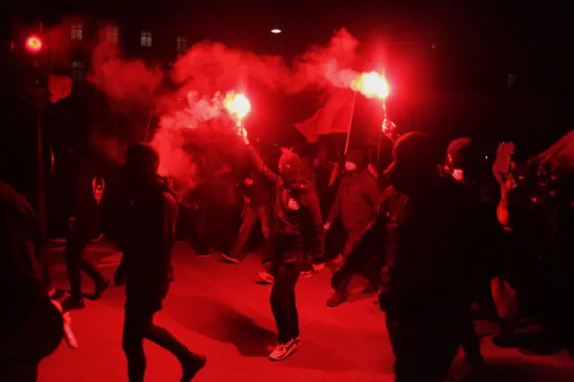 Demonstrators hold torches during a march against new Covid restrictions in Copenhagen, Denmark. Photo: November 2021