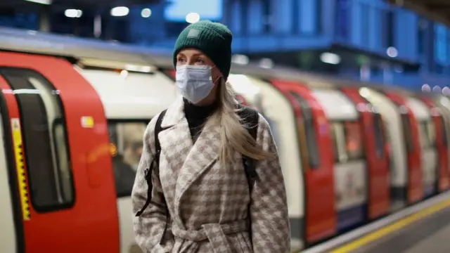 A woman walks in front of a London Underground train. File photo