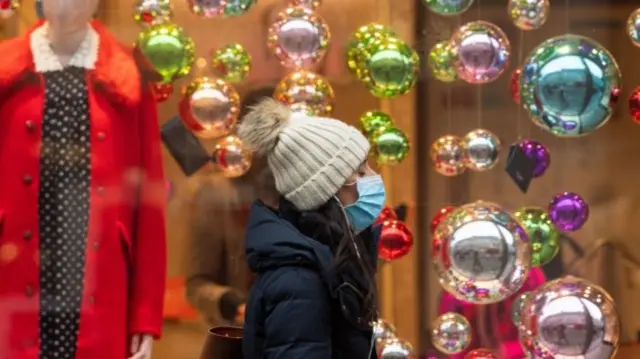 Woman walking past Christmas decorations