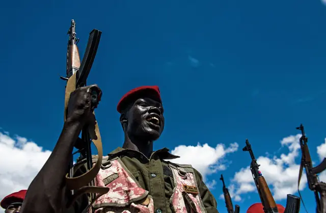 A Sudan People's Liberation Army (SPLA) soldier holds up a gun at a containment site outside Juba on April 14, 2016.