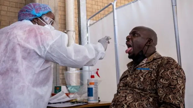 A healthcare worker conducts a PCR Covid-19 test at the Lancet laboratory in Johannesburg on November 30, 2021