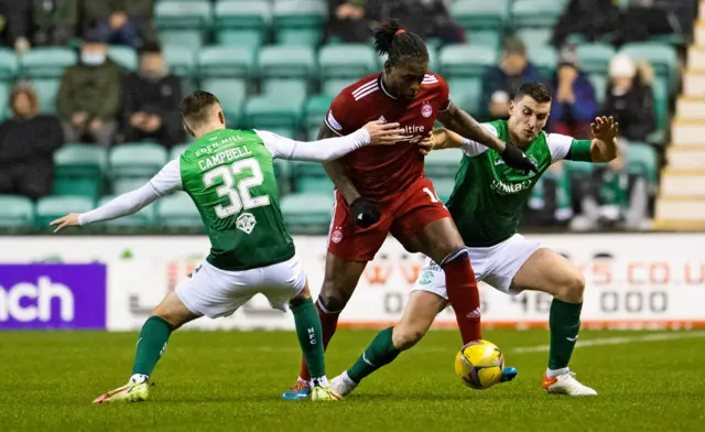 Aberdeen's Jay Emmanuel Thomas is challenged by Hibernians Paul Hanlon and Josh Campbell