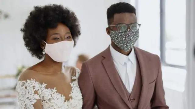 A couple get married wearing face masks