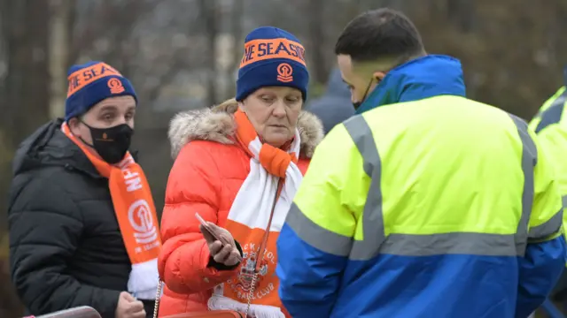 Blackpool fans show Covid passports to a steward