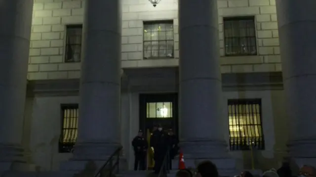 Police are seen looking over the crowd outside her court