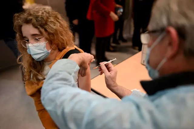 A child receives a dose of vaccine during France's Health Minister Olivier Veran's visit in a vaccination centre against Covid-19, in the 5th arrondissement of Paris