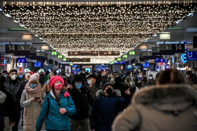 People wearing face masks jostle for a train inside the main station in Dusseldorf, Germany, 23 November 2021