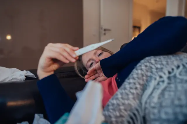 Woman looking at thermometer