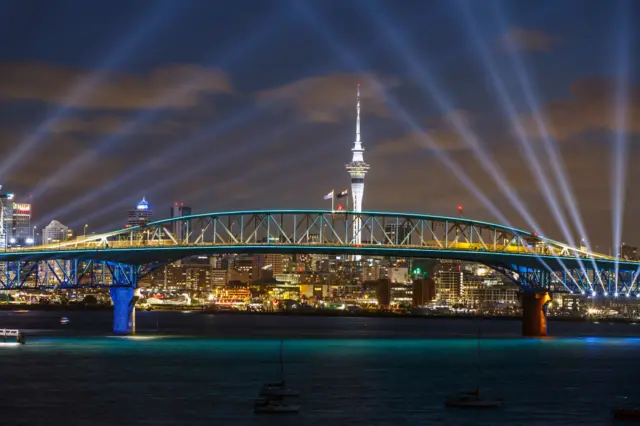 A light show from the Skytower and harbour bridge during Auckland New Year's Eve celebrations on 31 December 2021 in Auckland, New Zealand