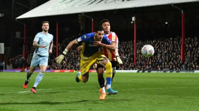 Kiko Casilla and Ollie Watkins challenge for the ball