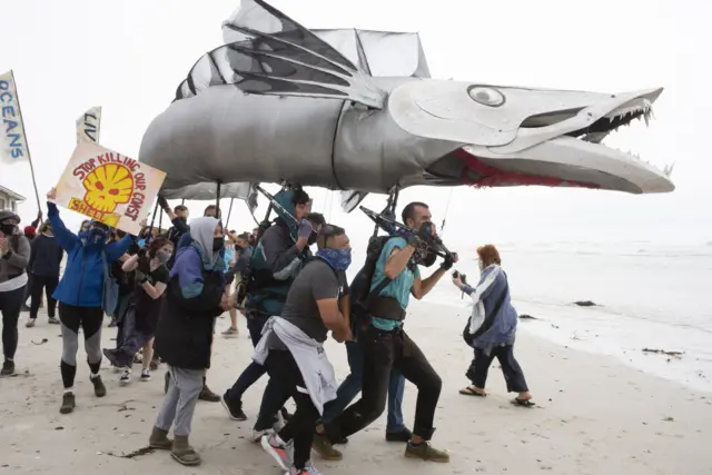 A giant puppet of a Snoek, a type of common local Mackeral, is displayed as hundreds of people take part in a protest against the plan by the oil company, Shell,