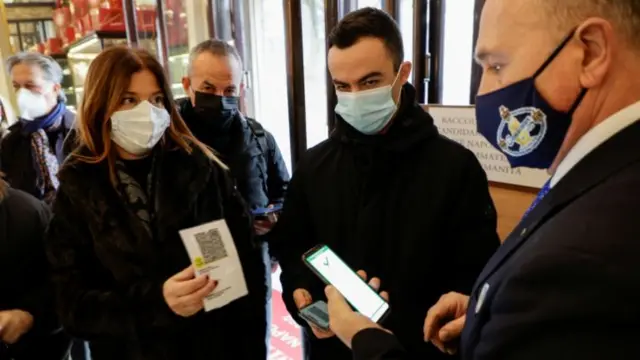 Customers have their green pass checked as they arrive at a bar