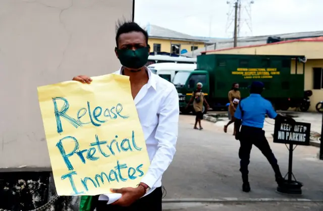 An activist holds a placard calling for release of pre-trial inmates