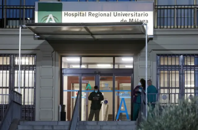 Health workers stand at the front entrance of the Malaga Regional University Hospital