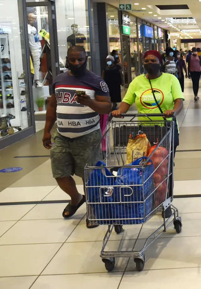 eople are seen at a shopping mall as they continue their daily life as the new omicron variant of the coronavirus detected