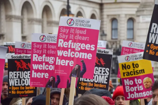 Protesters hold 'Refugees Welcome' placards during the demonstration in London