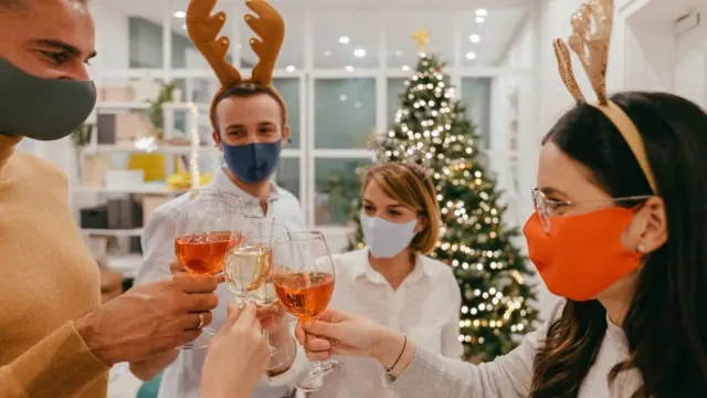 Four people make a toast at a Christmas party