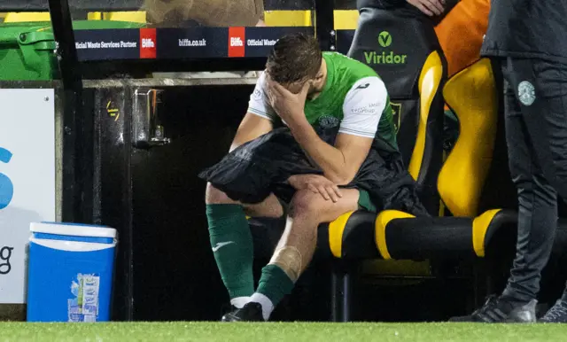 Hibs defender Ryan Porteous cuts a dejected figure on the bench after going off