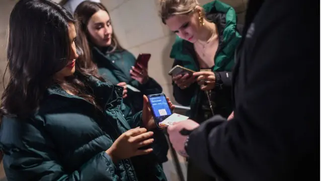 Images of women having Covid passports checked