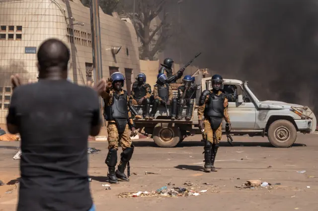 A protestor faces security forces during a demonstration in Ouagadougou on November 27, 2021.