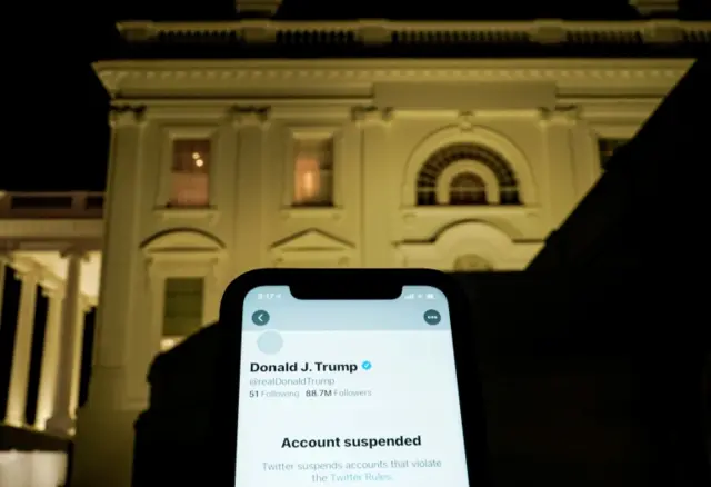 A photo illustration shows the suspended Twitter account of U.S. President Donald Trump on a smartphone and the White House in Washington, U.S., January 8, 2021. R