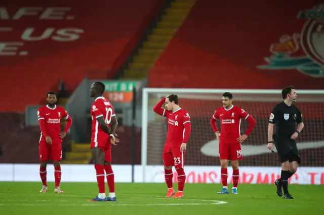 Liverpool players stand disappointed