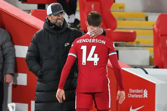 Liverpool's German manager Jurgen Klopp (L) consoles Liverpool's English midfielder Jordan Henderson (