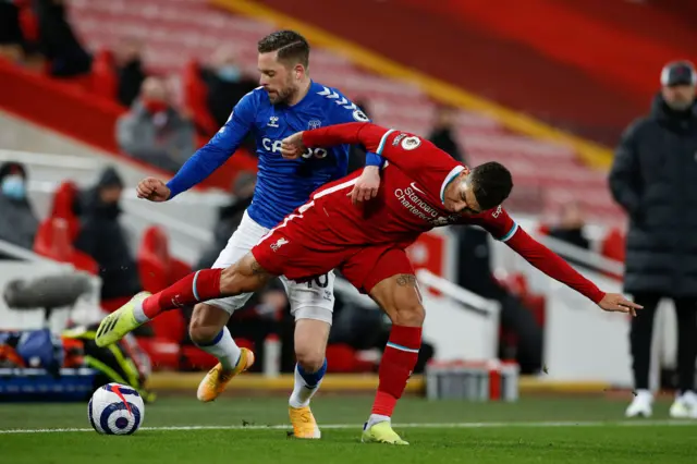 Everton's Icelandic midfielder Gylfi Sigurdsson (L) vies with Liverpool's Brazilian midfielder Roberto Firmino