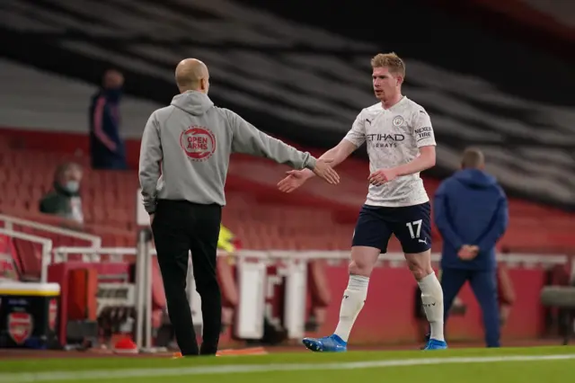 Kevin De Bruyne (R) of Manchester City interacts with Pep Guardiola