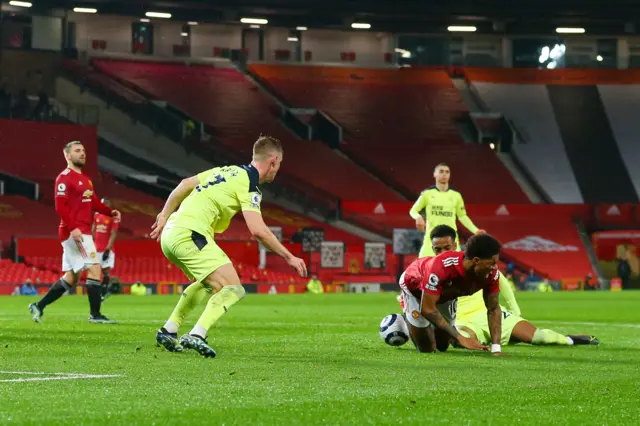 Joe Willock fouls Marcus Rashford to give away a penalty