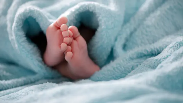 Baby feet poking out from under blanket