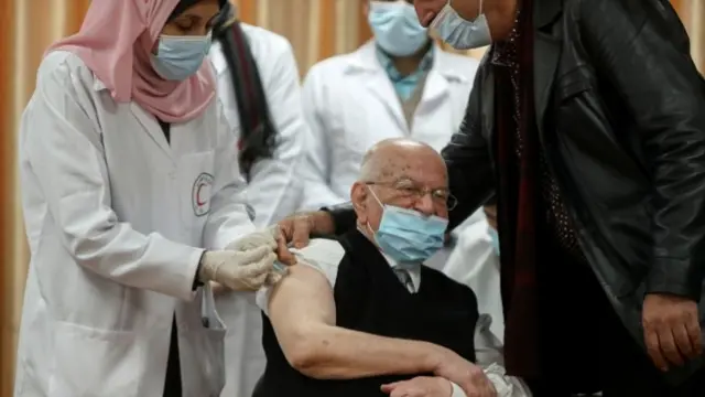 Former Palestinian health minister Riyad Zanoun receives a Covid-19 vaccine in Gaza City (22 February 2021)