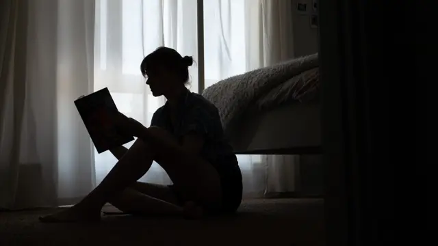 Woman reading in a bedroom