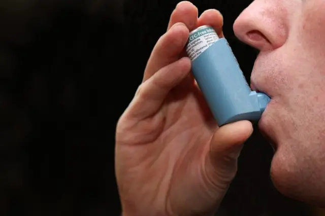 A man using an asthma inhaler