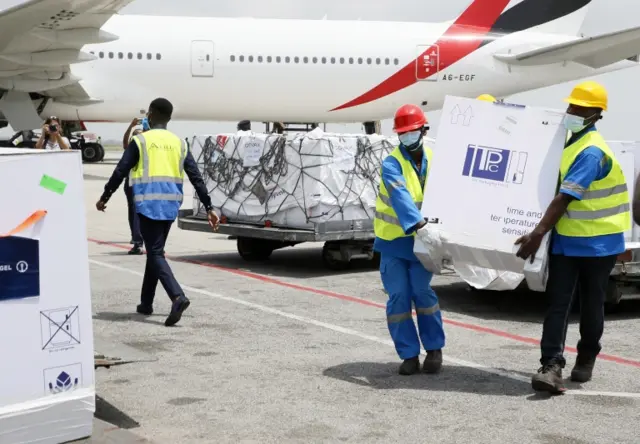 Workers unload boxes with the Oxford/AstraZeneca vaccine