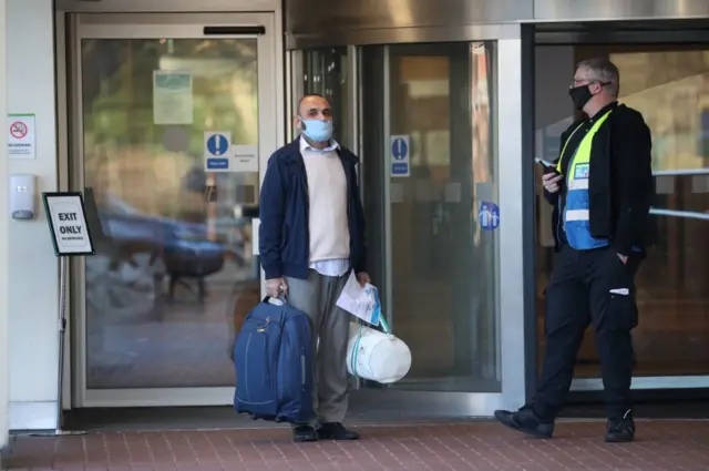 A guest leaves the Holiday Inn hotel near Heathrow Airport, London, after completing their 10-day stay at the Government-designated quarantine hote