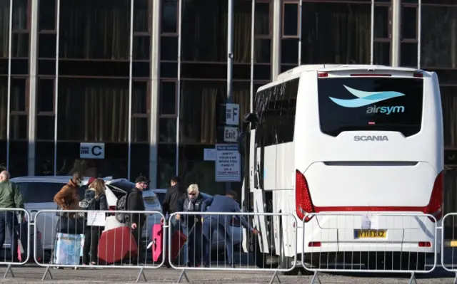 Guests leave the Radisson Blu Edwardian hotel, near Heathrow Airport, London, after completing their stay