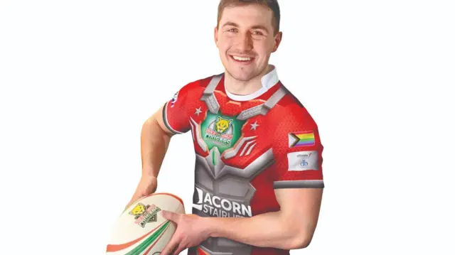 Rugby player wearing shirt with Progress Pride flag