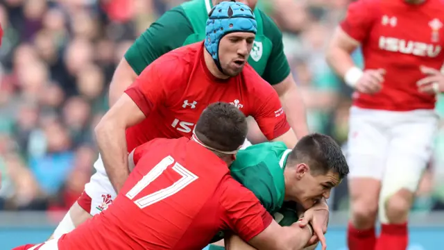 Johnny Sexton is tackled by Justin Tipuric and prop Wyn Jones during Ireland's Six Nations win over Wales in 2018