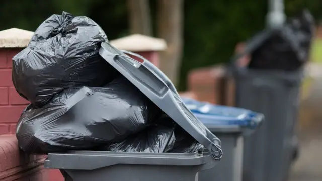 A wheelie bin full of rubbish